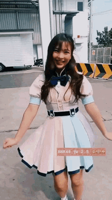 a girl in a colorful dress is standing in front of a sign that says bnk48 2.5