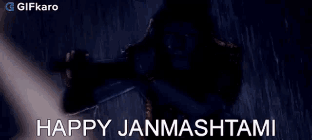 a statue of krishna is playing a flute in the rain and says happy janmashtami .