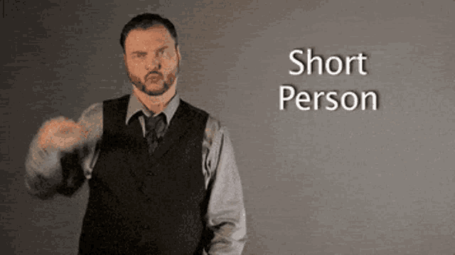 a man in a suit and tie is making a gesture that says short person