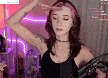 a woman with pink hair is standing in front of a microphone with a purple background