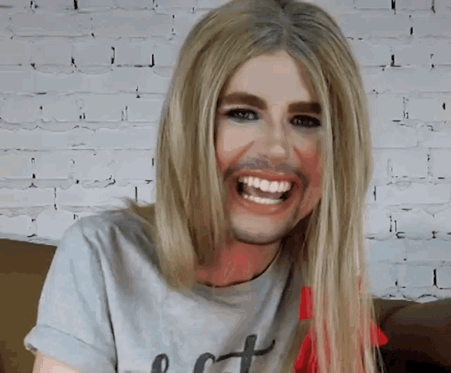 a woman with blonde hair and a beard is wearing a shirt that says i love