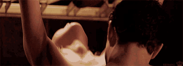 a man and a woman are having sex in a dark room and the man has a tattoo on his neck