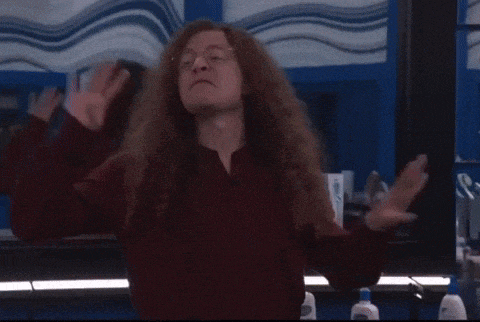 a woman in a red dress is dancing in a bathroom and giving a thumbs up