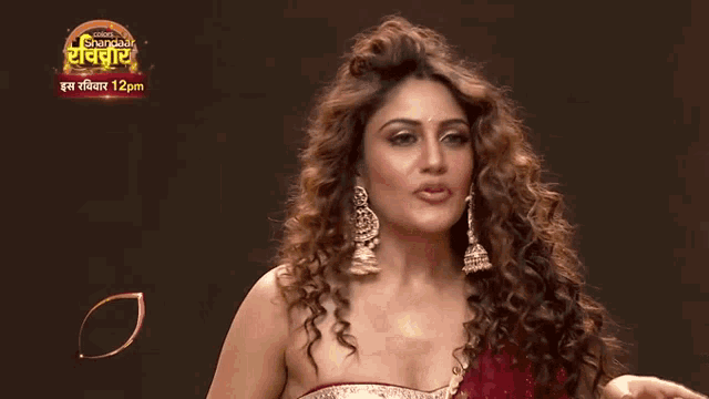 a woman is dancing in front of a sign that says ' shandaar '