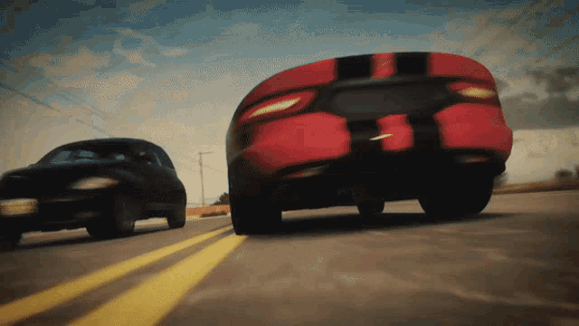 a black car and a red car are racing down a road