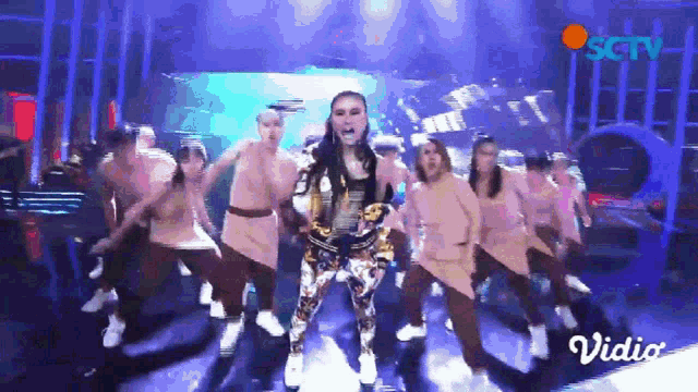 a group of women are dancing on a stage with the word vidio on the bottom