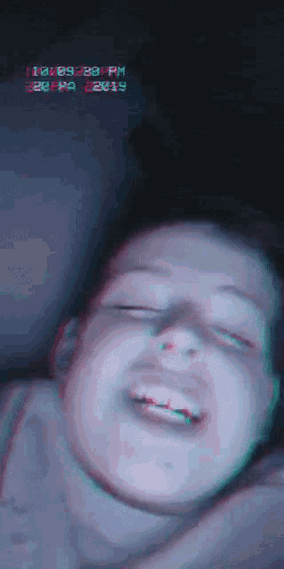 a blurry picture of a person 's face with the time of 11:59:29 pm on the bottom