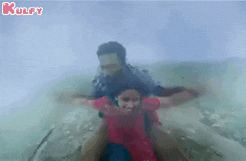 a man is carrying a woman on his shoulders in a boat .