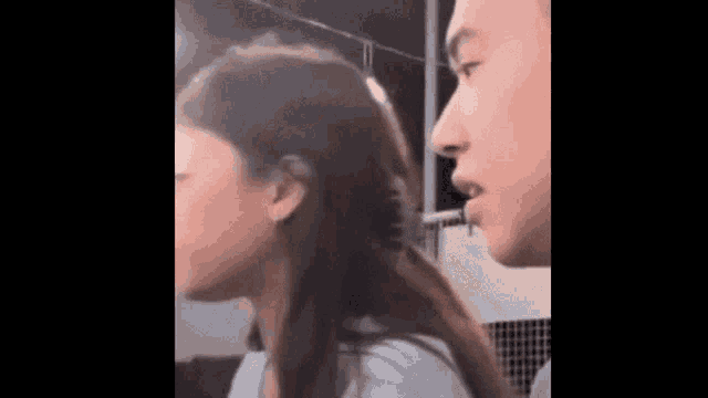 a man and a woman are looking at each other .