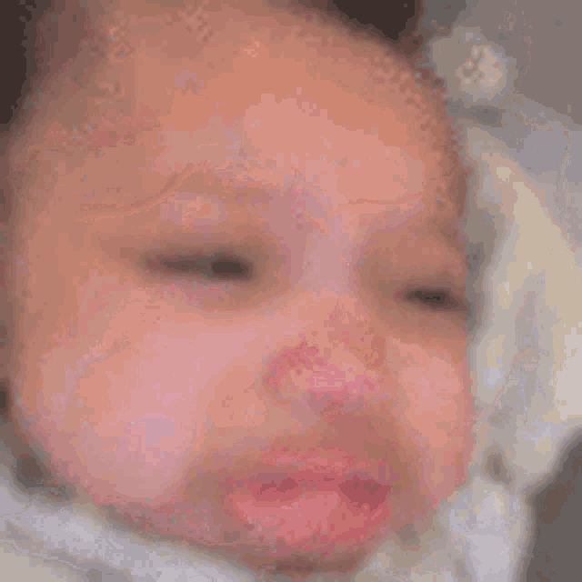 a close up of a baby 's face with its mouth open .