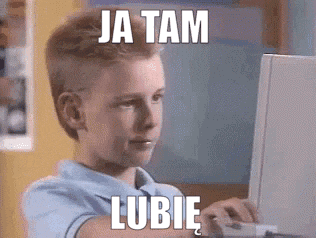 a young boy is typing on a laptop computer with a meme behind him .