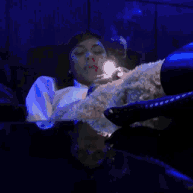 a blurry picture of a person swimming in a pool with a blue light behind them