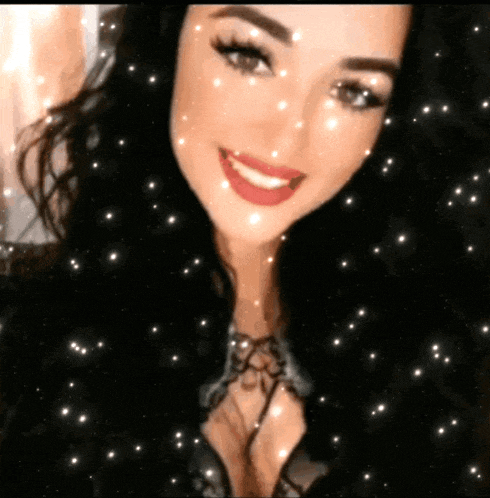 a close up of a woman 's face with snowflakes falling around her