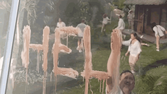 a group of people are standing in a field with the word help written on a window