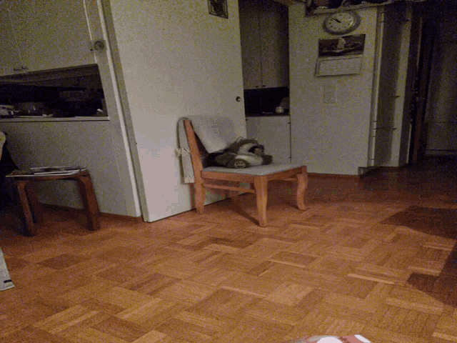 a kitchen with a clock on the wall and a chair on a counter