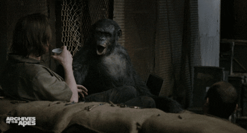 a man sitting next to a monkey with the words archives of the apes on the bottom right