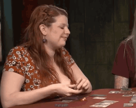a woman sitting at a table playing a game