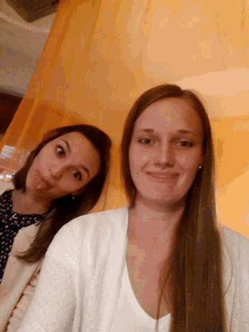 two women are posing for a picture and one is wearing earrings