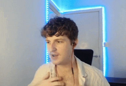 a man with curly hair is wearing ear buds and a white shirt .