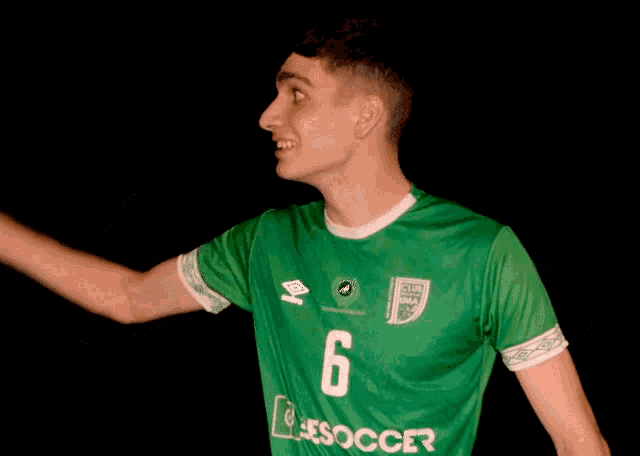 a man wearing a green jersey that says soccer on it
