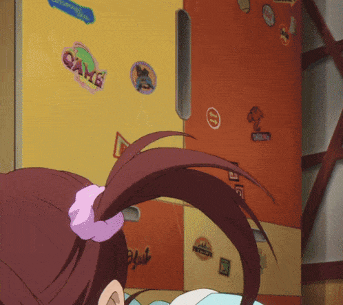 a girl with a ponytail stands in front of a fridge with stickers on it including one that says game