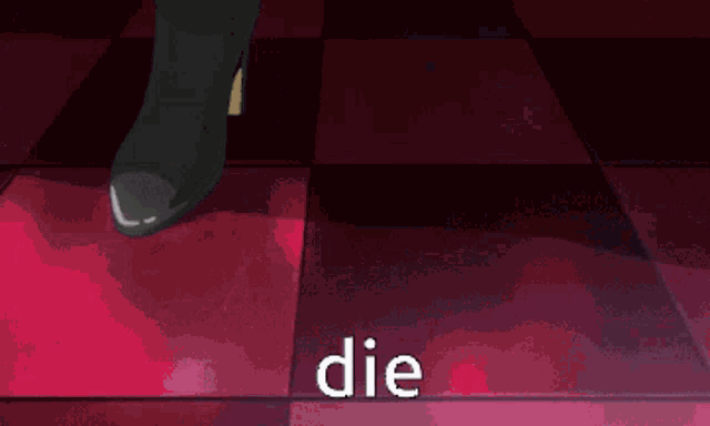 a man in overalls is standing in front of a couch with the word die written on his pants .