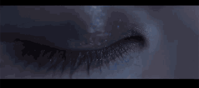a close up of a person 's eye with a blue glow