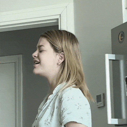 a woman stands in front of a lg refrigerator