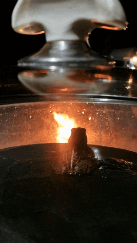 a close up of a glass container with a fire coming out of it