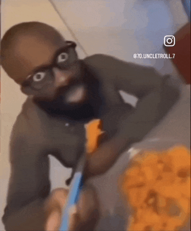 a man with glasses and a beard is eating a bowl of food .