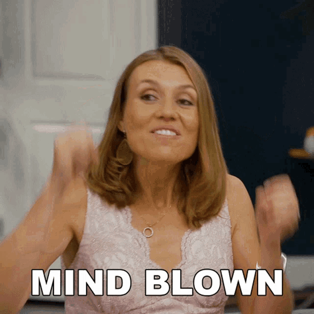 a woman in a pink dress says mind blown with her hands