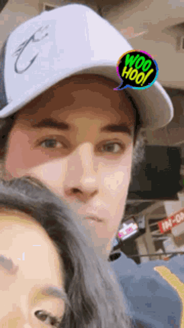 a man wearing a white hat has a woo hoo sticker on his face