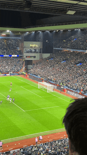 a soccer field with a mastercard banner on the side