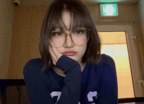 a girl wearing glasses and a blue sweater with the number 7 on it