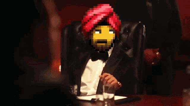 a man in a tuxedo with a red turban on his head