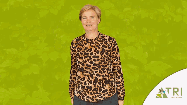a woman in a leopard print shirt stands in front of a green background with confetti and the word tri on it