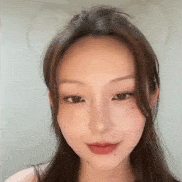 a close up of a woman 's face with long brown hair .