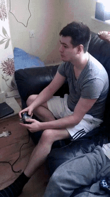 a young man sitting on a couch playing a video game