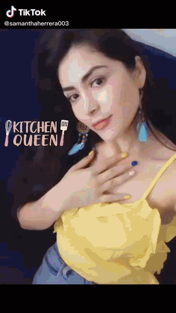 a woman in a yellow top is taking a selfie with the words kitchen queen above her