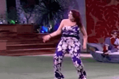 a woman in a floral jumpsuit is dancing