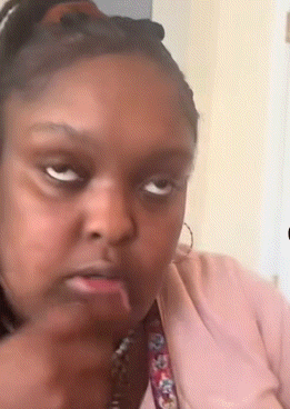 a woman in a pink shirt is making a funny face with her mouth open .