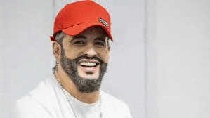 a man with a beard wearing a red hat is smiling .