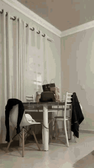 a dining room table and chairs with a purse on the table