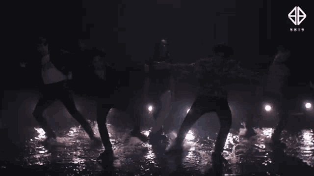 a group of people are dancing in a puddle of water .