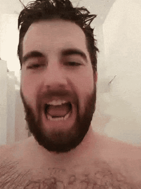 a shirtless man with a beard is screaming with his mouth open