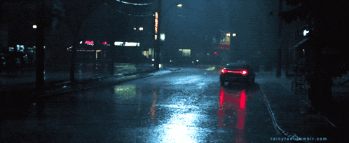a car is driving down a wet street in front of a mcdonalds
