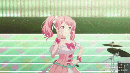 a girl in a pink dress is standing on a stage