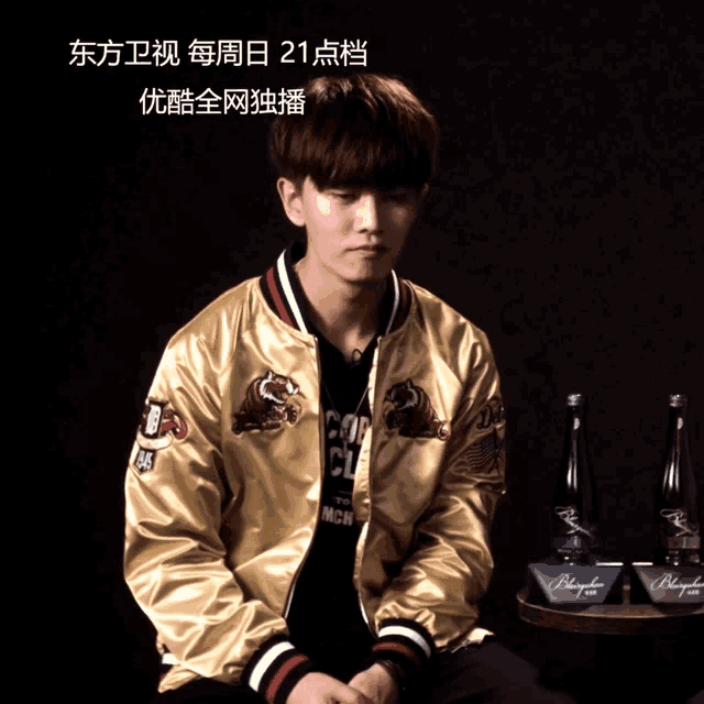 a man wearing a gold jacket has a speech bubble with chinese writing on it