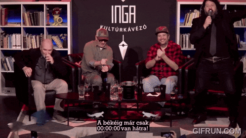 a group of men sit in front of a sign that says inga kulturkavezo