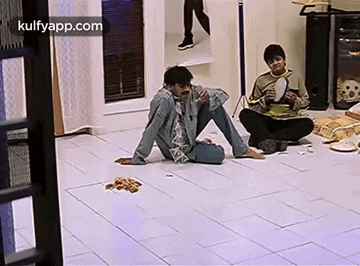 a man and a woman are sitting on the floor in a living room .